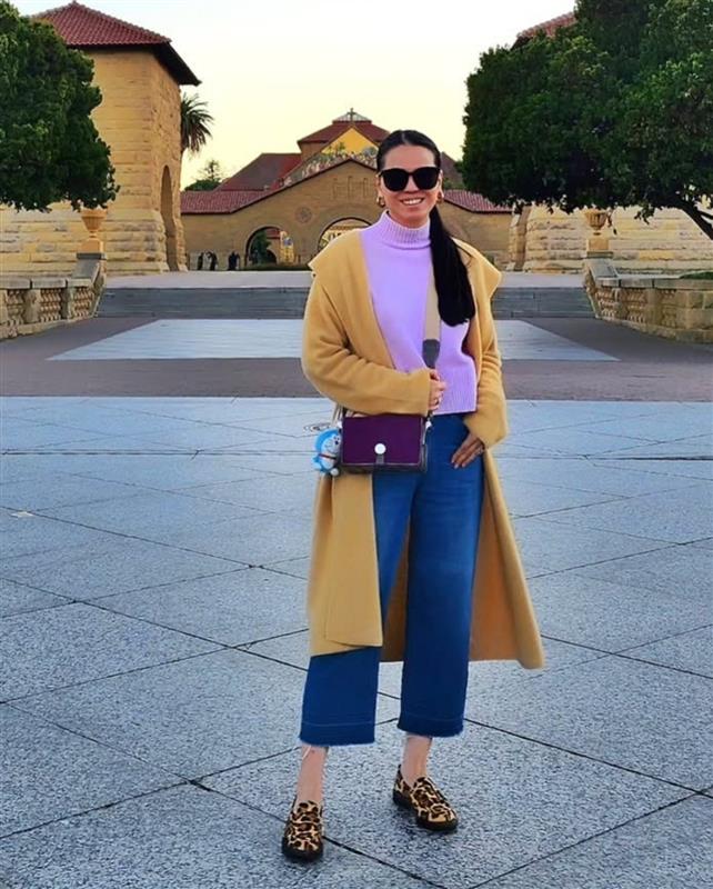 Portrait of Ingrid Chua wearing a floral top, gray skirt and black boots