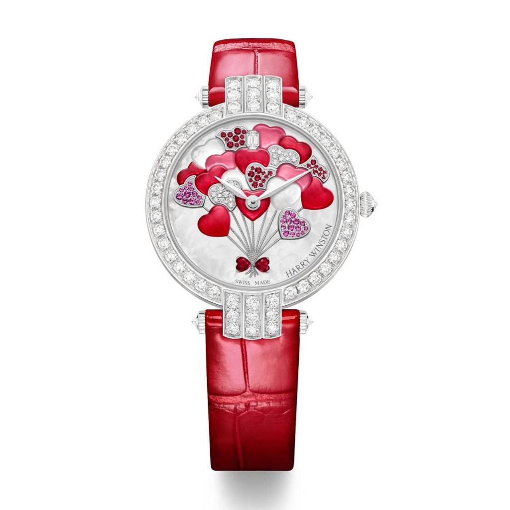 Harry Winston round face watch with red leather strap and heart balloon detailing on the face