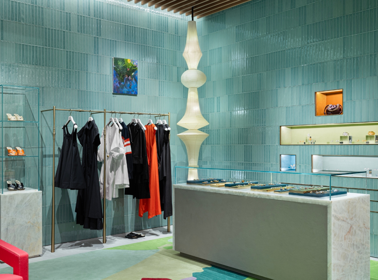 Interior of Loewe’s new Bal Harbour Shops boutique with walls adorned with aquamarine tiles and racks and shelves of product