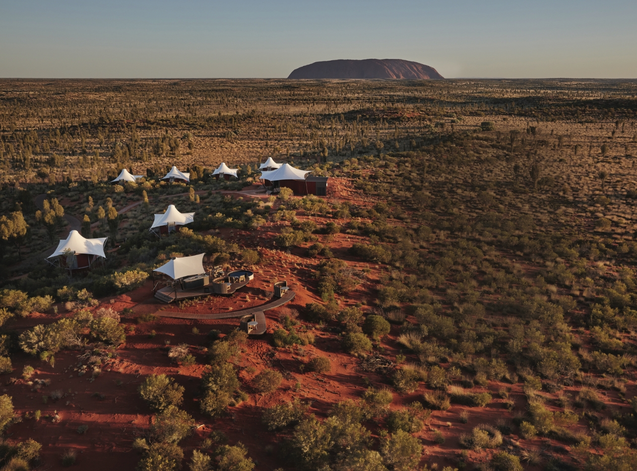 Aerial shot of Longitude 131 glamping experience with red dire, white tents and trees surrounding