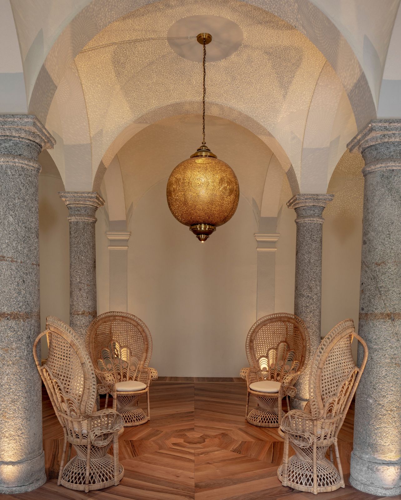 The Spa loinge at the Passalacquea hotel includes wicker chairs with glass chandelier hanging from ceiling with gray stone columns