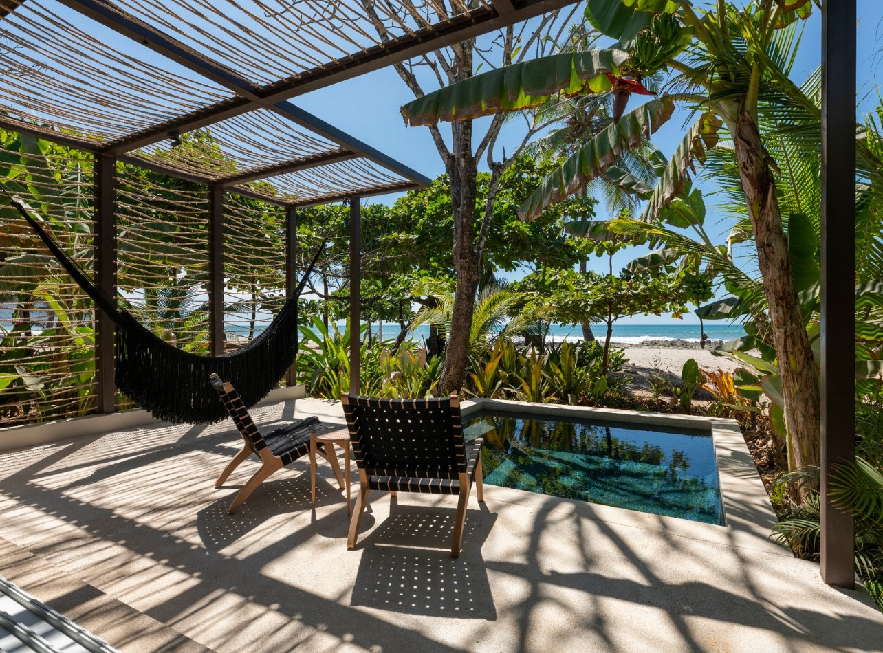 pool with canopy and lounge chairs with view of the beach