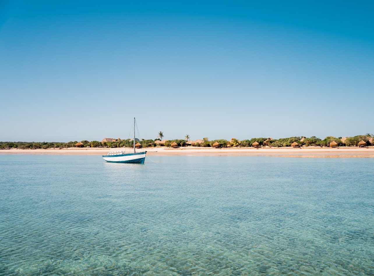 Ocean view with sailboat and villas in the distance at Azura in Bazaruto