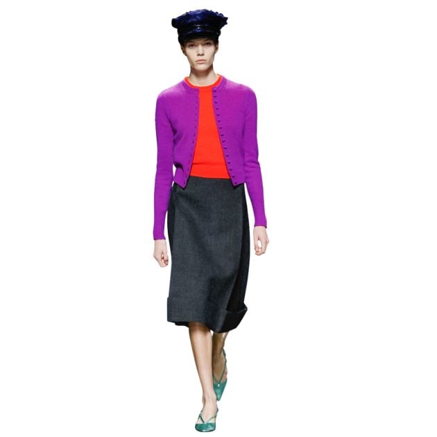 Prada model wearing a purple cardigan, red top, gray skirt and blue heels