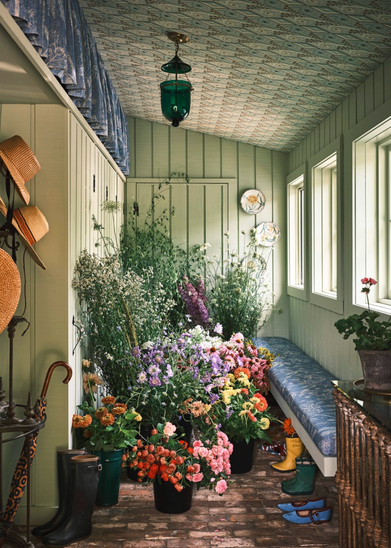 Mudroom with mint-green walls and ceiling wallpapered with a geometric pattern filled with various colored flowers