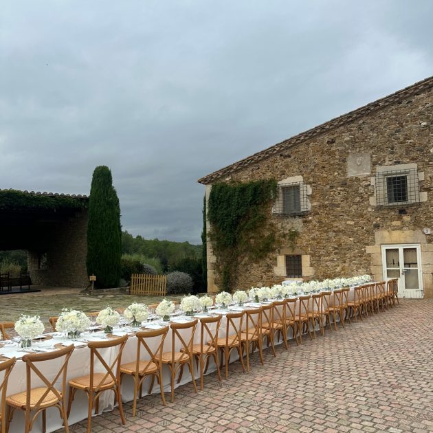 Long table running down center of a cobblestone vineyard