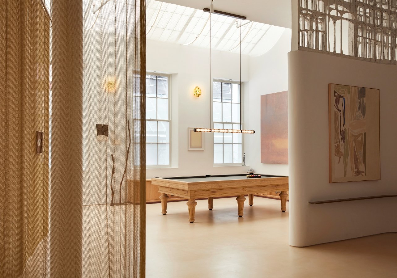 Room with a pool table and chandelier hanging above