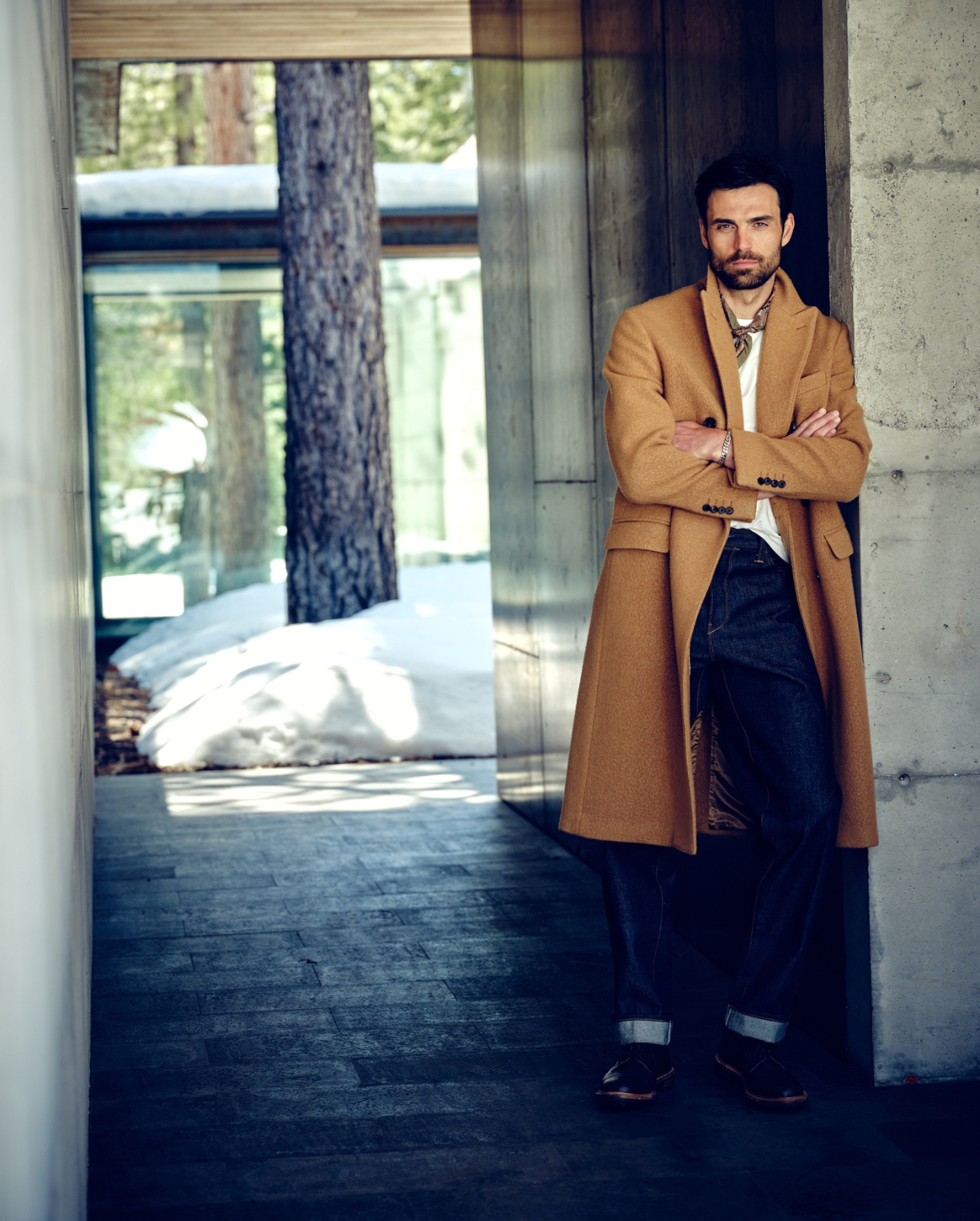 Todd Snyder October collection campaign with male model wearing camel coat leaning against a wall