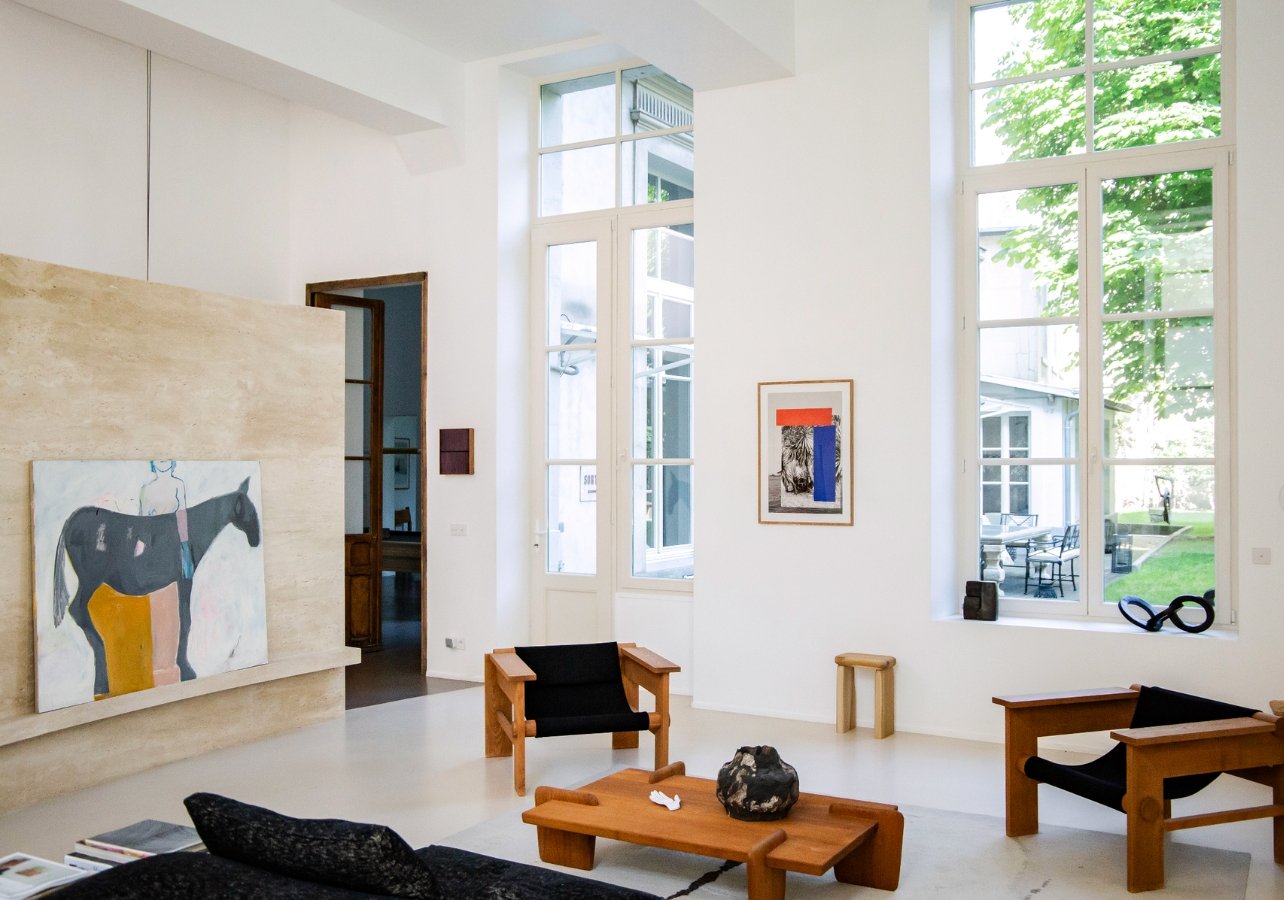 Living room with furinute and a painting sitting on travertine wall with a horse painted