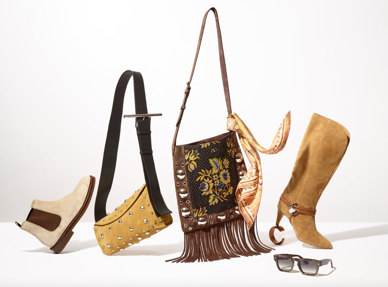 The bohemian gift guide hero with a variety of items including yellow bag with silver studs, brown fringe bag