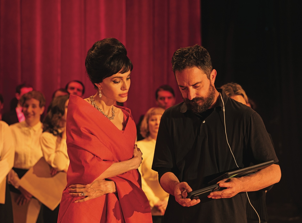 Angelina Jolie wearing a red dress side by side with director