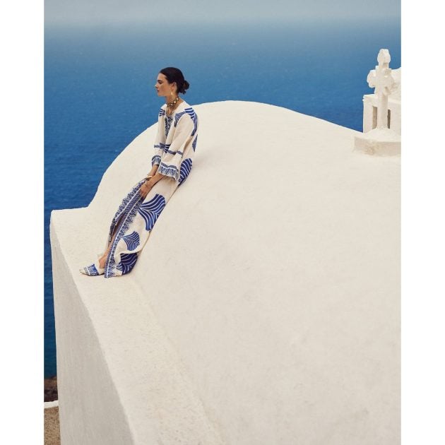 Model on white Roof in Greece with water view in background