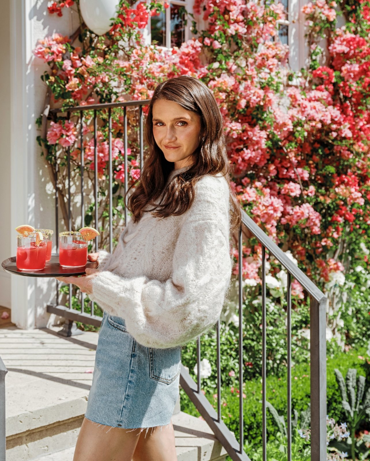 Portrait of Tieghan Gerard holding a tray of pink drinks