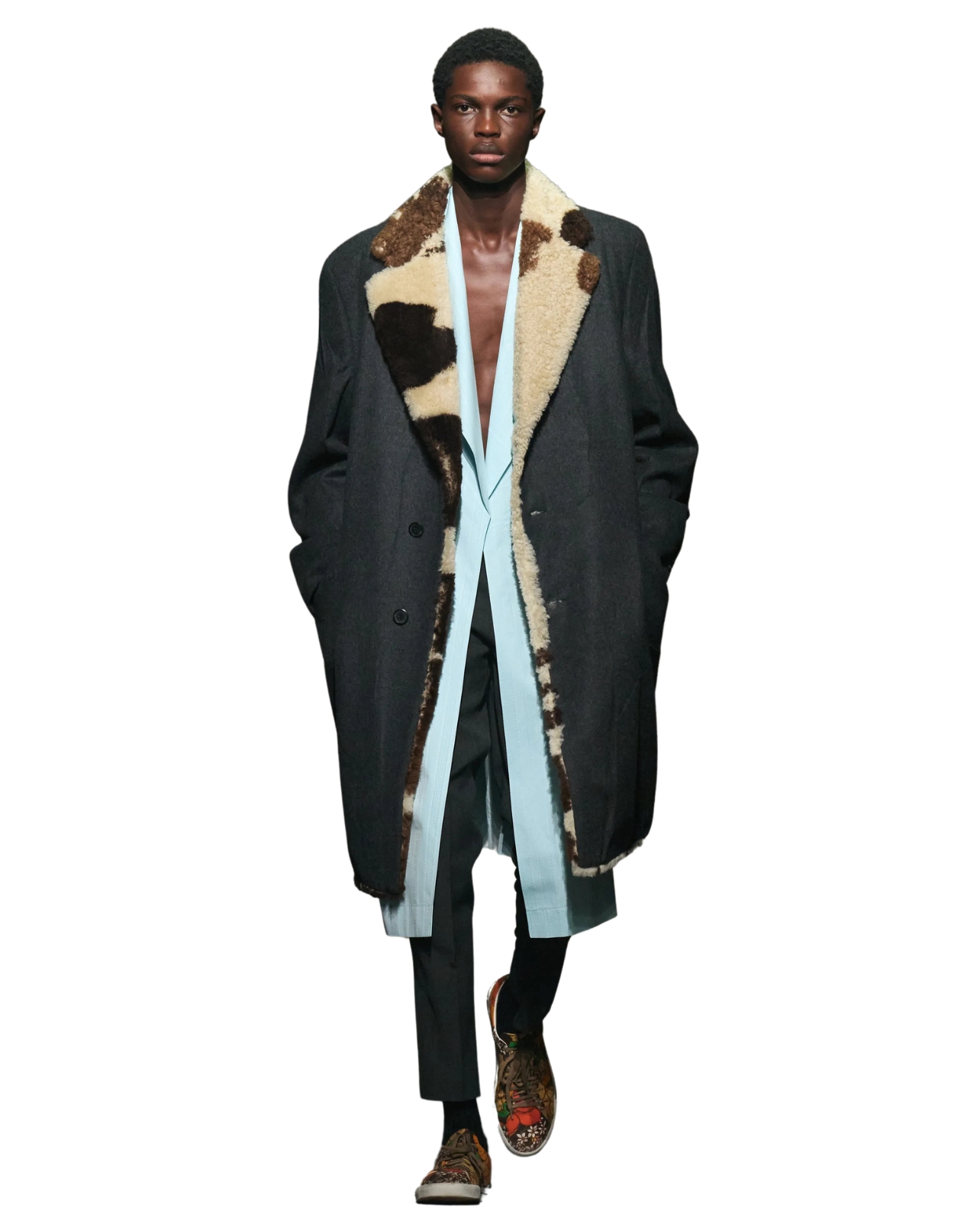 Prada male model wearing a large coat with fur trim and a blue shirt underneath