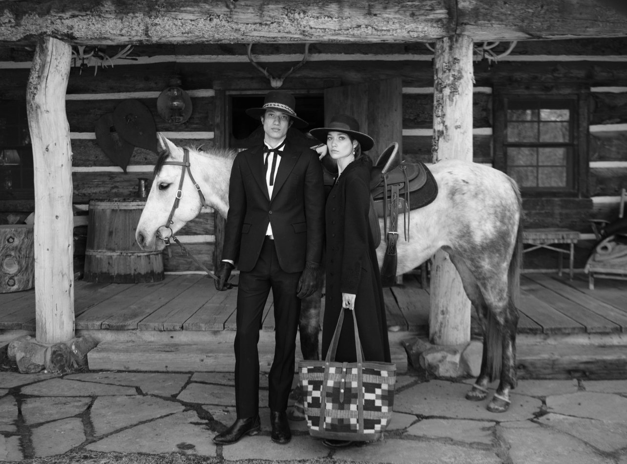 Ralph Lauren female and male models standing in front of a horse in black and white