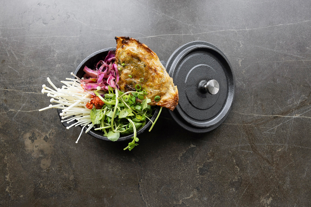 Aerial view of a dish filled with greens and bread