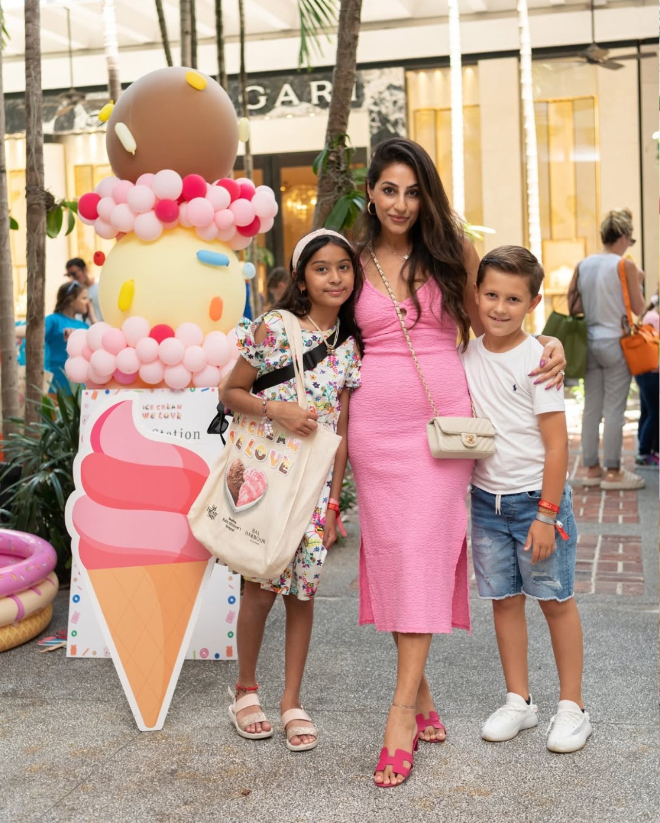 Woman in pink with two children next to her