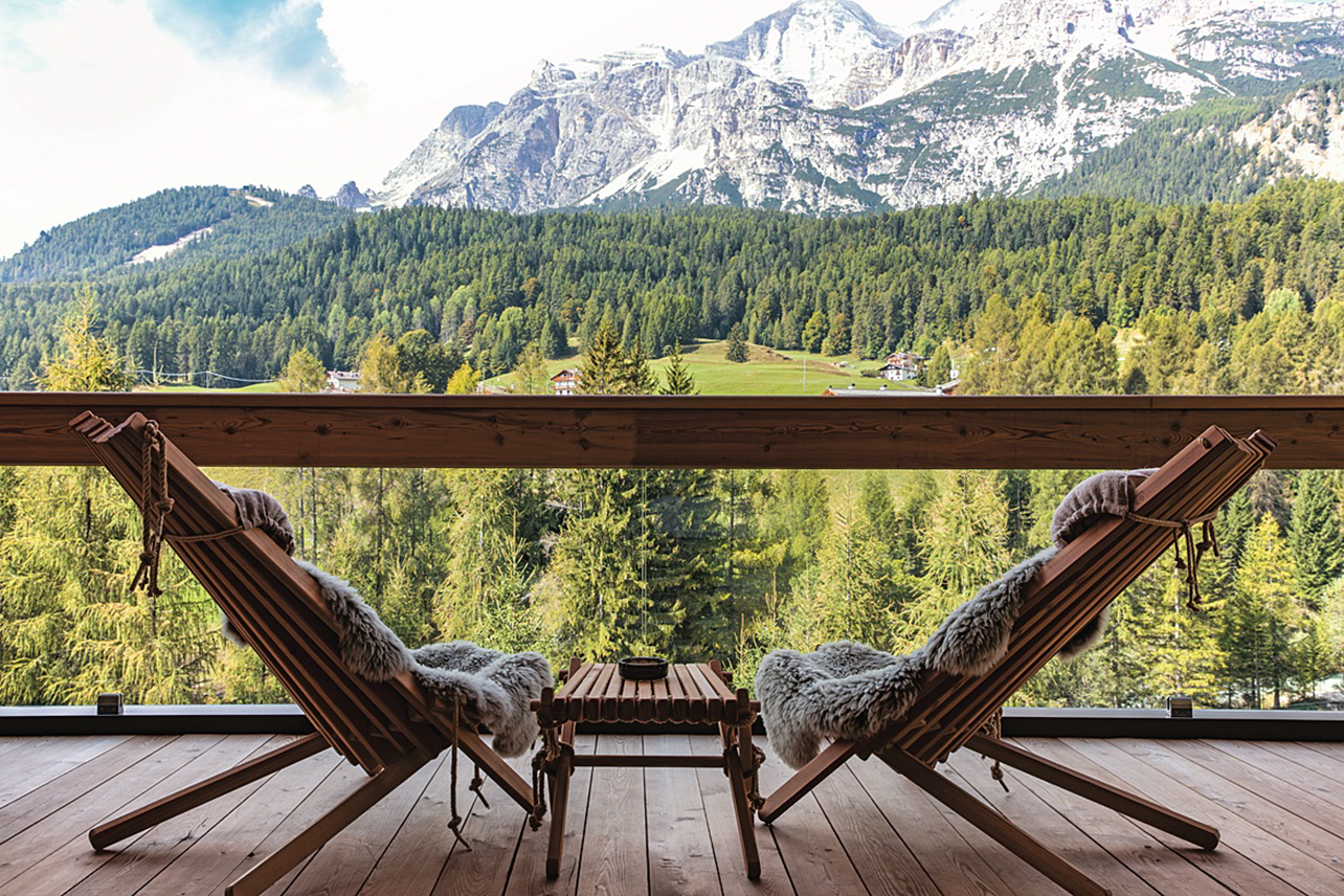 Wooden deck with two chairs with view out mountains and trees