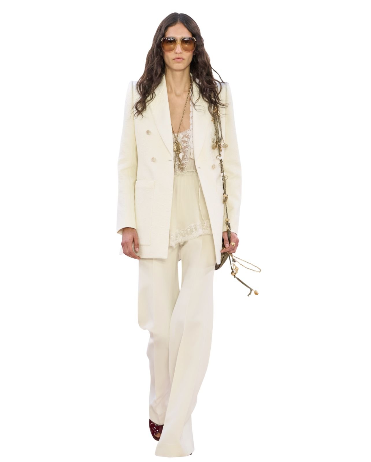 Chloe model wearing a long cream blazer and pants with large sunglasses